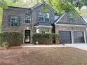 Beautiful two-story brick home featuring a well-manicured front yard and black front door at 5789 Star Flower Dr, Ellenwood, GA 30294