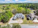 An aerial view showing the home's circular driveway, manicured lawn and mature trees, providing a private setting at 1660 Norris Landing Dr, Snellville, GA 30039