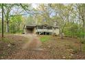 Charming home nestled amongst trees with a long driveway leading to a screened-in porch and carport at 5026 Daniel Mill Rd, Winston, GA 30187