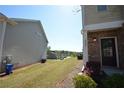 A townhome featuring brick siding, a side door, and green lawn and landscaping at 5829 Taka Ln, Lithonia, GA 30038