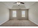 Spacious bedroom with plush carpet, two windows, and a modern ceiling fan at 6205 Leverett Dr, Lithonia, GA 30038