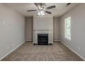 Comfortable living room featuring plush carpet, a ceiling fan, and a classic fireplace at 6205 Leverett Dr, Lithonia, GA 30038