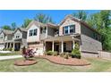 Beautiful home with manicured front lawn, decorative landscaping, and a covered front porch with stately columns at 1835 Wellston Dr, Lawrenceville, GA 30043