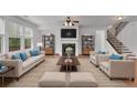 Bright living room featuring a fireplace, plush seating, hardwood floors, and staircase access at 21 Belmore Manor Dr, Suwanee, GA 30024