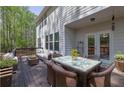 A lovely outdoor patio features an outdoor dining set, a wicker couch, and a wooden deck at 21 Belmore Manor Dr, Suwanee, GA 30024