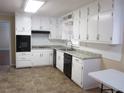 Bright kitchen featuring ample white cabinetry, tiled floor, and modern appliances at 2107 Briarwood Ct, Snellville, GA 30078