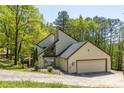 Contemporary home with a black roof and an attached two car garage surrounded by green trees at 2295 Piedmont Ridge Ct, Marietta, GA 30062
