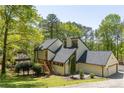 Modern home with a black roof, wooden stairs, well-manicured lawn, and attached two car garage at 2295 Piedmont Ridge Ct, Marietta, GA 30062
