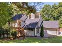 Stylish home with a black roof, wooden stairs, and a spacious front yard with ample green space at 2295 Piedmont Ridge Ct, Marietta, GA 30062