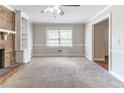 Cozy living room featuring neutral colors, a brick fireplace, and natural light at 6330 Phillips Pl, Lithonia, GA 30058