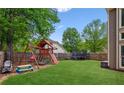 Spacious backyard featuring a playset, trampoline, and a well-maintained lawn at 1005 Anise Ct, Dacula, GA 30019