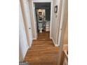 Hallway showcasing hardwood floors leading to bathroom with tiled walls at 1075 Peachtree Ne Walk # 506, Atlanta, GA 30309