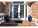 Inviting brick front porch with double doors, adorned with wreaths and blue decorative pots at 120 Milano Sw Dr, South Fulton, GA 30331