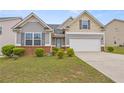 Inviting exterior featuring gray siding, a two-car garage, a well-maintained lawn, and tasteful landscaping at 256 Bollen Ln, Hiram, GA 30141