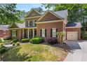 Beautiful two-story brick home with manicured lawn, mature trees, and an attached two-car garage at 4862 Tarry Post Ln, Suwanee, GA 30024
