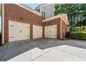 Spacious three-car garage with white doors and a large concrete driveway providing ample parking at 4862 Tarry Post Ln, Suwanee, GA 30024