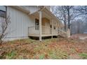 View of side porch with wooden railings, offering a cozy outdoor space and covered area at 5520 Hearn Rd, Ellenwood, GA 30294