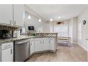 Modern kitchen with white cabinets, granite countertops, and stainless steel appliances at 220 Cameron Ways, Covington, GA 30016