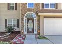 Inviting front entrance with decorative glass door, stone accents, and manicured landscaping at 7228 Silverleaf Cir, Fairburn, GA 30213