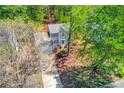 Aerial view of a home nestled among trees with a driveway and lush green lawn at 11205 Abbotts Station Dr, Duluth, GA 30097