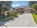 A two-story brick home exhibits lush landscaping and a lengthy driveway leading to the attached garage at 1490 Rivershyre Pkwy, Lawrenceville, GA 30043