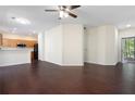 Open concept living room with dark wood floors connecting to an adjacent kitchen area and sliding glass doors at 548 W Oaks Dr, Woodstock, GA 30188