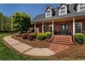 Stunning brick home features a welcoming front porch with brick steps and mature landscaping at 200 Sugar Mill Ln, Canton, GA 30115