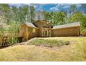 Rear exterior view of a brick home with an elevated deck and a spacious yard at 1660 Weems Rd, Locust Grove, GA 30248