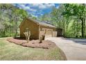 Side view of the brick garage with a two car garage door and landscaping at 1660 Weems Rd, Locust Grove, GA 30248