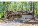 One story brick home featuring a two car garage and mature trees at 2352 Rockwood Way, Stone Mountain, GA 30087