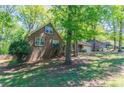 Side view of a brick home with a lush green lawn and mature trees at 2352 Rockwood Way, Stone Mountain, GA 30087
