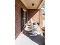 Inviting front porch features rocking chairs, brick walls, and natural light at 9989 Village South Dr, Douglasville, GA 30135