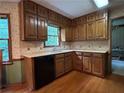 Traditional kitchen featuring wood cabinets, neutral countertops, and a window over the sink at 3798 Lee Ridge Sw Way, Lilburn, GA 30047