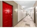 Hallway view of the building interior featuring neutral walls, tile flooring, and bright red apartment door at 400 17Th Nw St # 2125, Atlanta, GA 30363