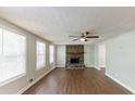 Bright living room featuring a stone fireplace, wood floors, a ceiling fan and natural light at 4170 N Quail N Dr, Douglasville, GA 30135