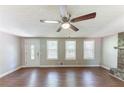 Living room showcasing wood floors, a ceiling fan, a stone fireplace and a white front door at 4170 N Quail N Dr, Douglasville, GA 30135