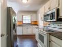 Functional kitchen with stainless steel refrigerator, white cabinets, and wood-look floors at 101 Valleydale Dr, Stockbridge, GA 30281
