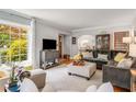 Living room with hardwood floors, a large window, a gray sofa, and an ottoman, with a view into the dining area at 1157 Hancock Ne Dr, Atlanta, GA 30306