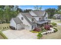Aerial view showing a large driveway leading to a home with a prominent three-car garage and beautifully landscaped front yard at 3039 Malbec Vly, Acworth, GA 30101