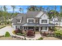 Two-story home boasts a covered front porch, professional landscaping, a mix of painted brick, and stone accents at 3039 Malbec Vly, Acworth, GA 30101