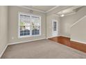 Inviting living room with large window, neutral walls, and plush carpeting at 679 Barley Hill Ln, Sugar Hill, GA 30518