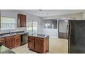 Open kitchen featuring an island, granite countertops, dark cabinets and stainless appliances at 5011 Wewatta Sw St, Atlanta, GA 30331