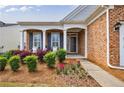 Inviting front porch with seating and landscaping adds curb appeal to this brick home at 4265 Prince Charles Dr, Duluth, GA 30097