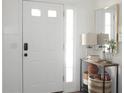 Bright foyer with white walls, a decorative table, and a front door with sidelight at 745 Abbotts Mill Ct, Johns Creek, GA 30097