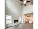 Bright living room featuring soaring ceilings, a modern fireplace, and sleek wood flooring at 123 Deer Xing, Temple, GA 30179