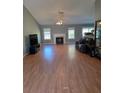 Inviting living room features wood floors, a cozy fireplace, and large windows for natural light at 1235 Jasmine Green Ct, Dacula, GA 30019