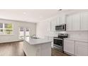 Bright kitchen features an island and stainless steel appliances at 290 Silver Moon Drive # 111, Loganville, GA 30052