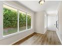 Bright hallway with wood-look flooring, white walls, and a view of a well manicured yard at 1371 Branch Dr, Tucker, GA 30084