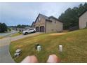 View of the home's side, showing the two-car garage, driveway, and side yard at 1750 Stone Meadow Rd, Lithonia, GA 30058