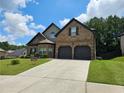 Charming two-story brick home with a well-manicured lawn and two-car garage at 1750 Stone Meadow Rd, Lithonia, GA 30058